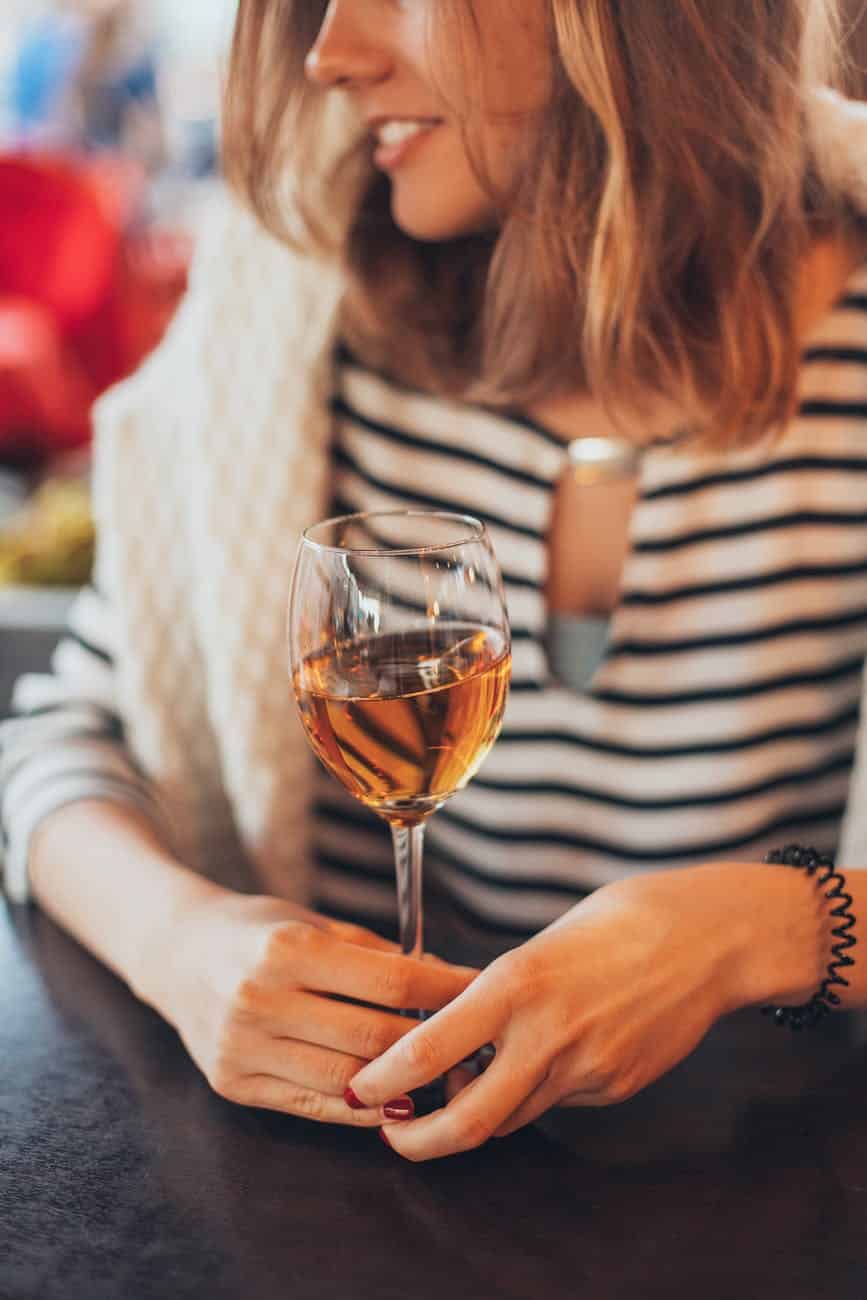 woman holding glass of wine as a non food reward
