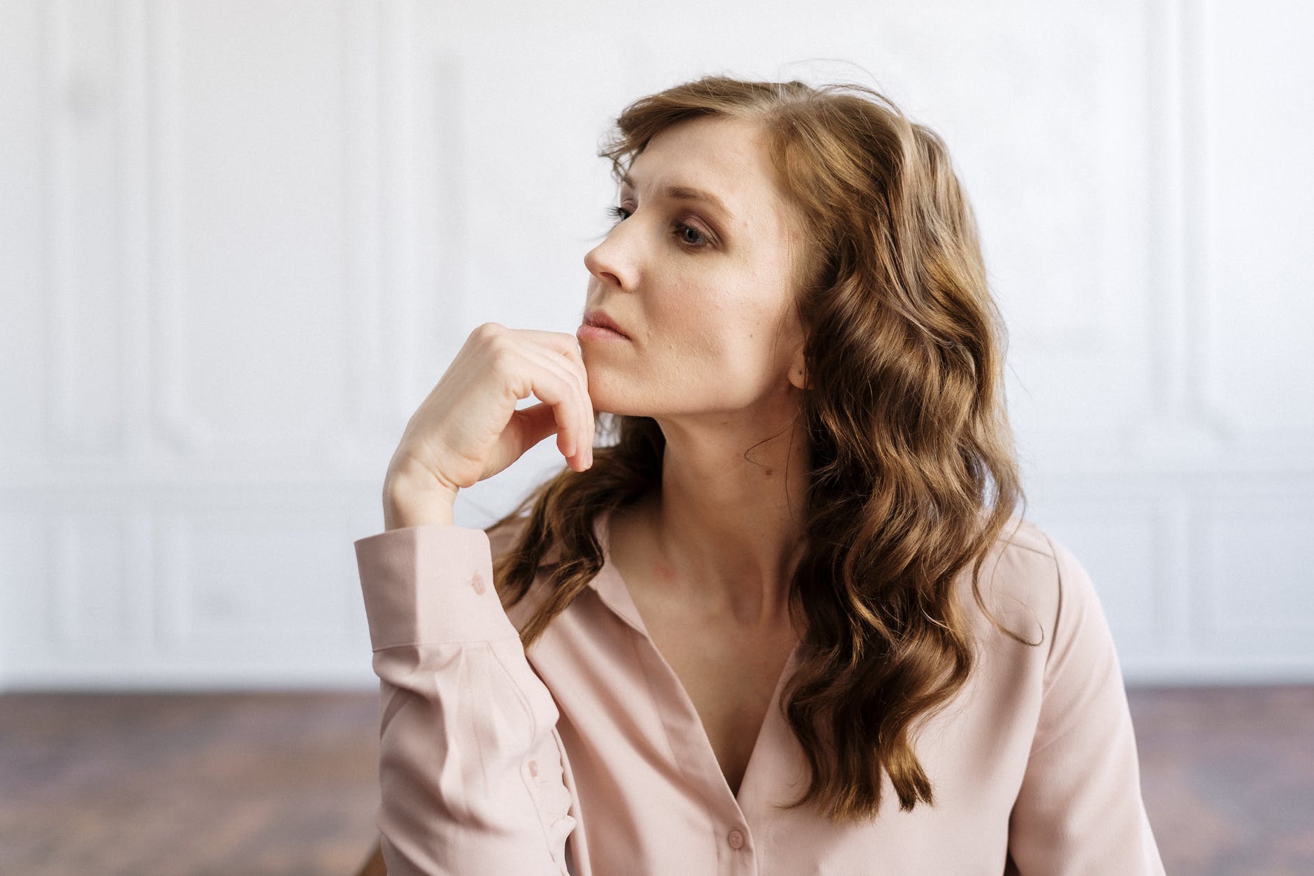 woman in white button up shirt in deep thought about mistakes