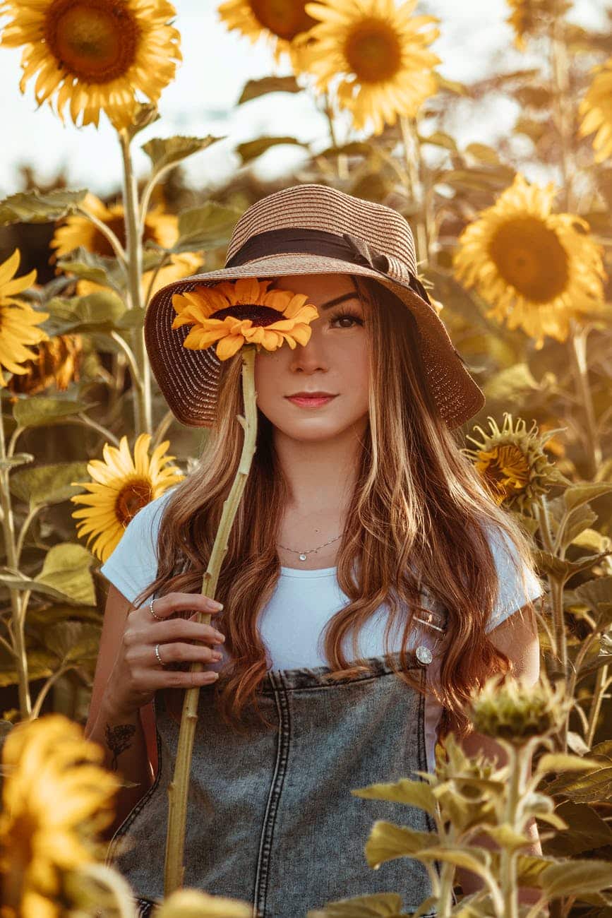 woman covering her eye with a sunflower